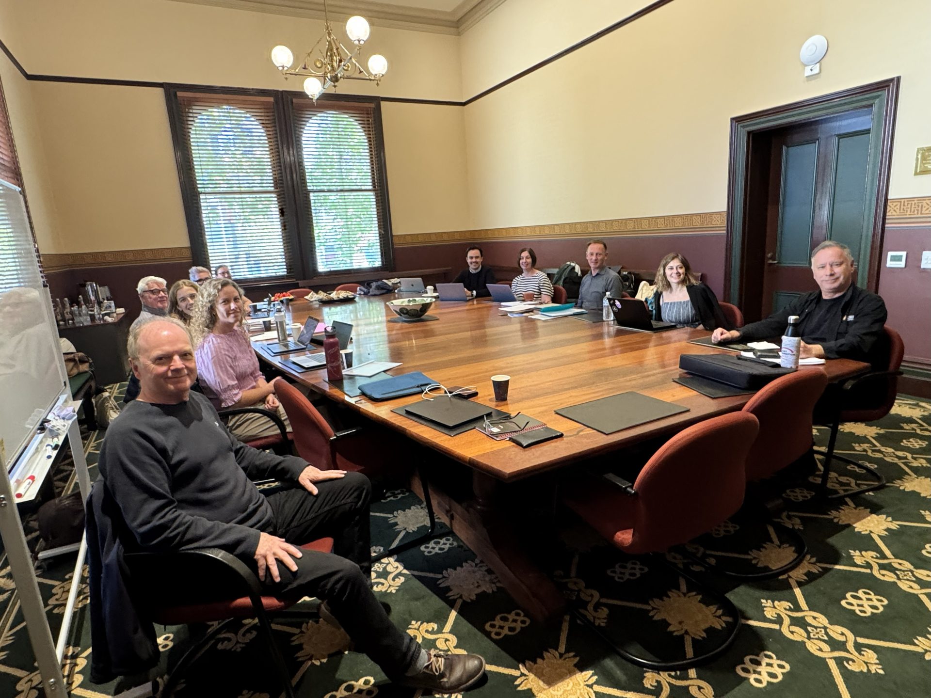 Redegeringsgruppen sider rundt om et bord til  workshoppen i Melbourne.