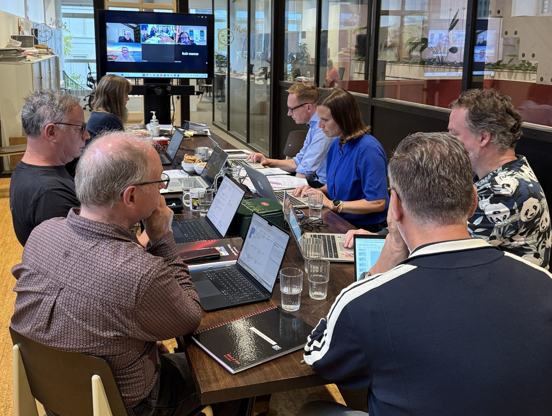 Redigeringsgruppen sidder ved et bord og arbejder til workshop i Ghent.