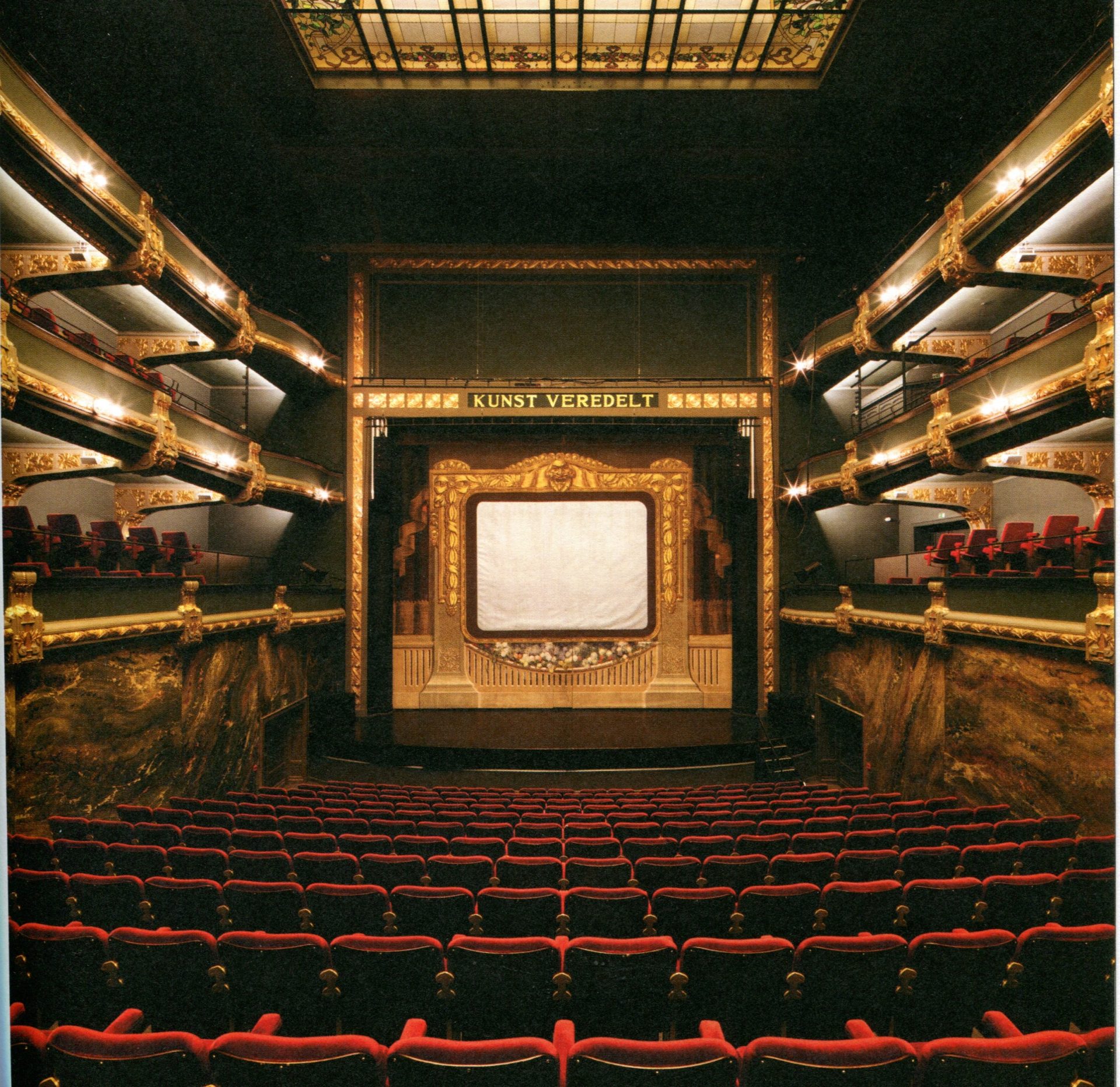 Teatersal, røde stofsæder  og guldfarvede dekorationer mod scenen.
